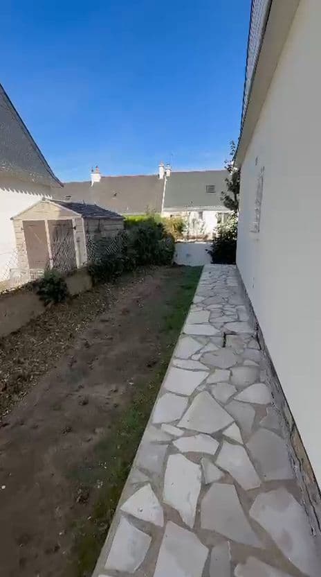Jardin de pavillon débroussaillé, pas japonais dégagés et bûches rangées contre la haie