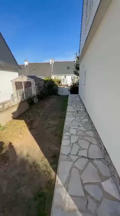 Passage entre la maison et la clôture, débarrassé de la végétation, vu vers le cabanon de jardin